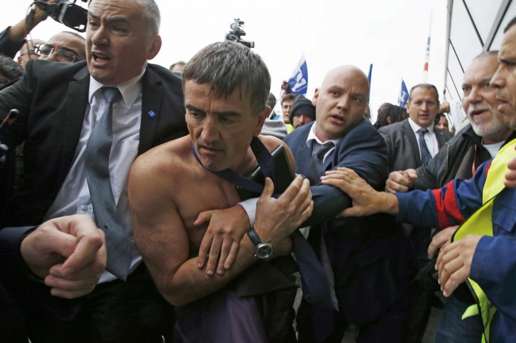 A shirtless Xavier Broseta Executive Vice President for Human Resources and Labour Relations at Air France is evacuated by security