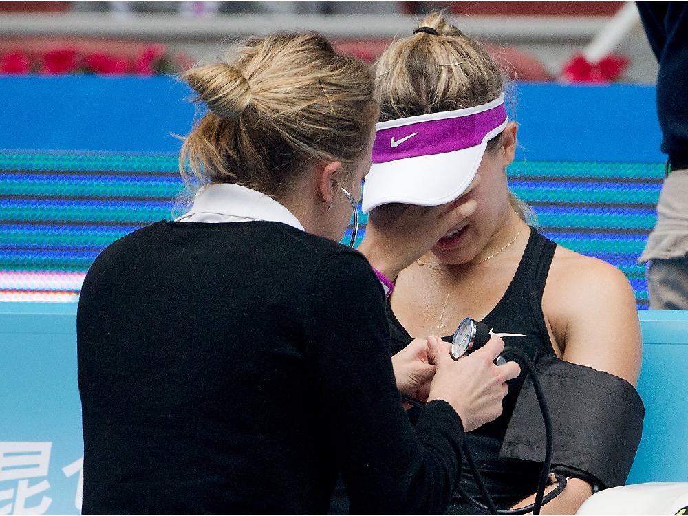 Eugenie Bouchard of Canada reacts as she receives medical attention during her first round match against Andrea Petkovic of Germany in the China Open tennis tournament at the National Tennis Stadium in Beijing Monday Oct. 5 2015