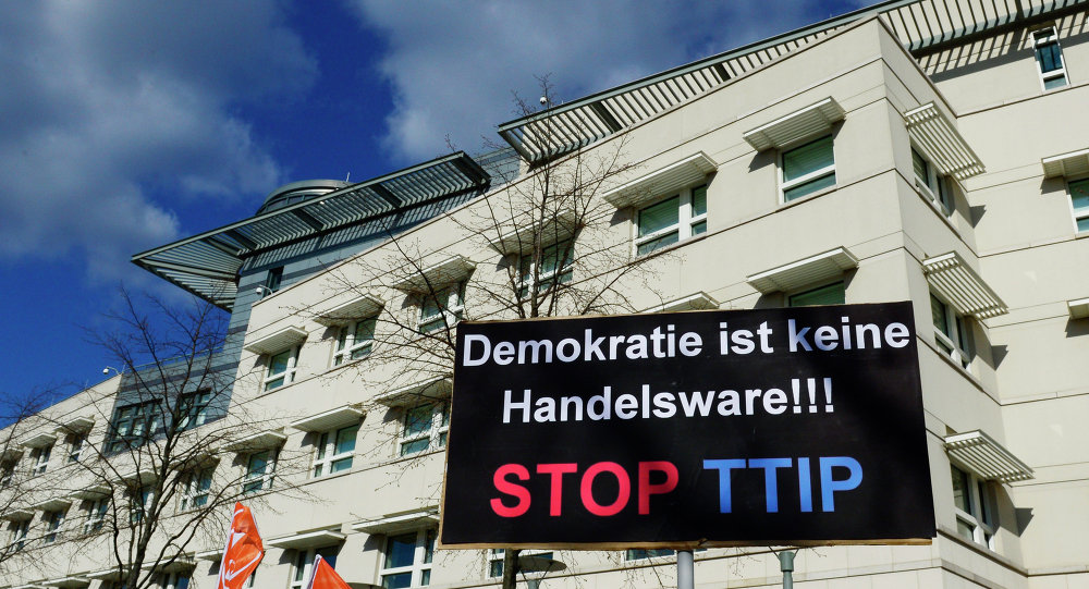 A sign reading Democracy is no trading good Stop TTIP is lifted in front of the US embassy during a protest against the proposed US-EU free trade pact or Transatlantic Trade and Investment Partnership in Berlin