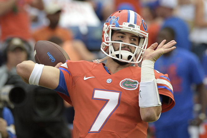 Florida quarterback Will Grier warms up before an NCAA college football game against Mississippi Saturday Oct. 3 2015 in Gainesville Fla. Mississippi head coach Hugh Freeze watches from the sideline after a Florida