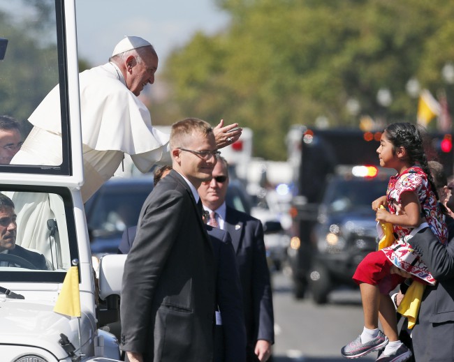 ADDS NAME OF GIRL- Pope Francis reaches to give a blessing to Sophie Cruz 5 from suburban Los Angeles during a parade in Washington Wednesday Sept. 23 2015. She also delivered a bright yellow T-shirt and a letter expressing wishes that her mother