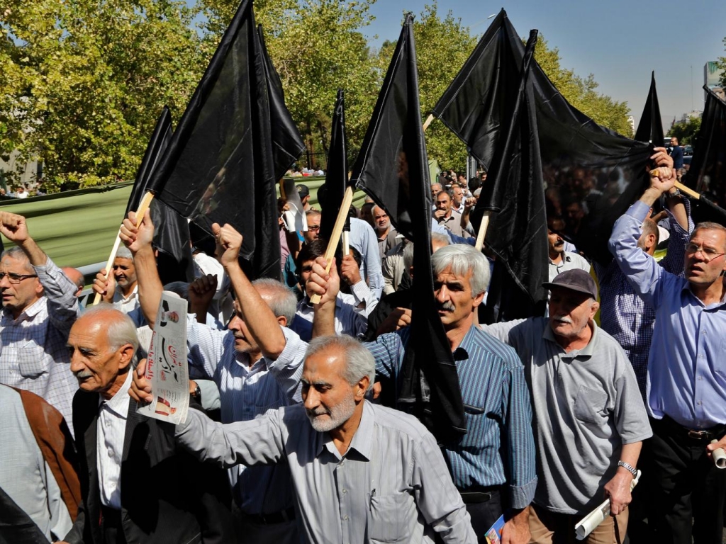 Iranians wave black flags in a show solidarity with those killed while performing Hajj in Mecca during a protest condemning Saudi Arabia for their role in the tragedy