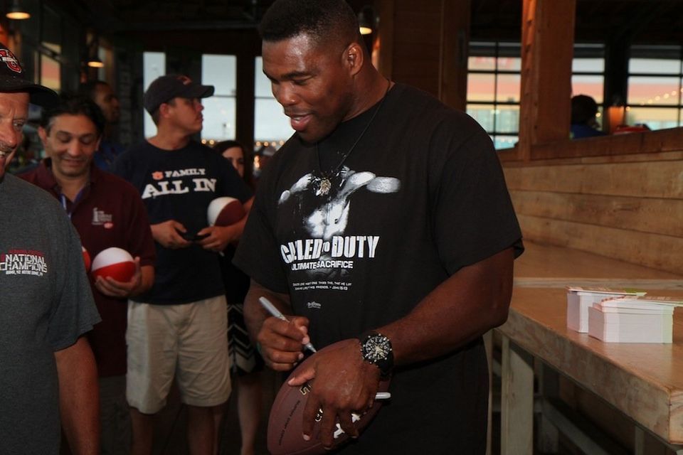 Herschel Walker signs an autograph for a fan during an appearance at SEC Beach Fest in Gulf Shores in 2013