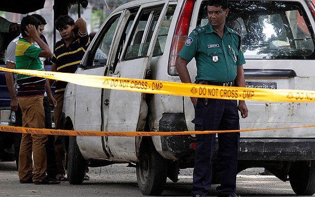 Members of Bangladeshi police and detective branch stand by the site where Italian citizen Cesare Tavella was gunned down by unidentified assailants in Dhaka Bangladesh Tuesday Sept. 29 2015