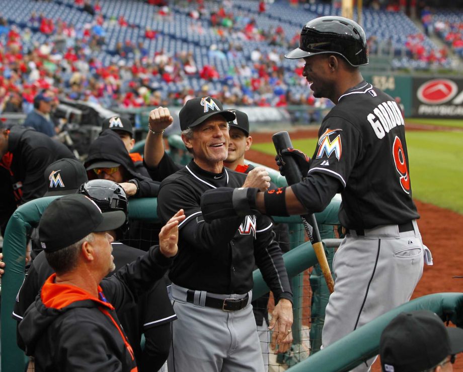 Miami Marlins Dee Gordon is congratulated in the dugout by teammates after scoring on a double by Justin Bour in the first inning against the Philadelphia Phillies during a baseball game Sunday Oct. 4 2015 in Philadelphia