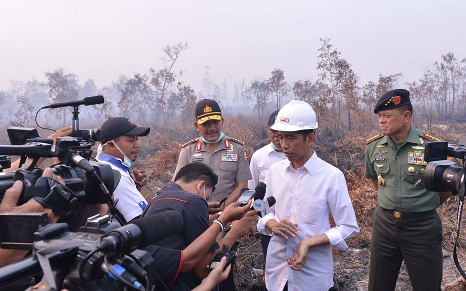 Indonesian President Joko Widodo talks to reporter during a visit to burned forest