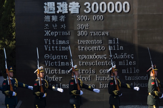 Chinese honor guard members march past the words “Victims 30,0000” during a ceremony to mark China’s first National Memorial Day at the Nanjing Massacre Memorial Hall