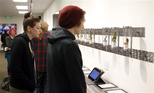 Customers look at product displays at Shango Premium Cannabis in Portland, Ore. Thursday Oct. 1 2015. Oregon marijuana stores have begun sales to recreational users marking a big day for the budding pot industry in the state. Some of the more than 2