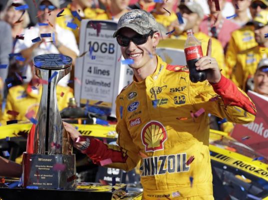 Joey Logano poses with the trophy in Victory