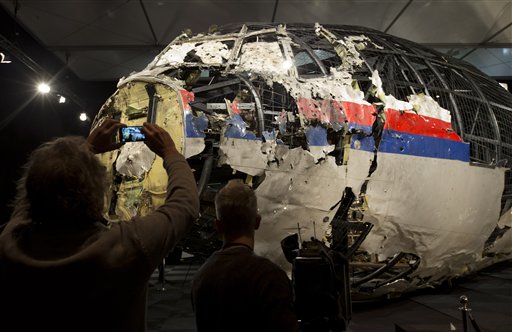 Journalists take images of part of the reconstructed forward section of the fuselage after the presentation of the Dutch Safety Board's final report into what caused Malaysia Airlines Flight 17 to break up high over Eastern Ukraine last year killing