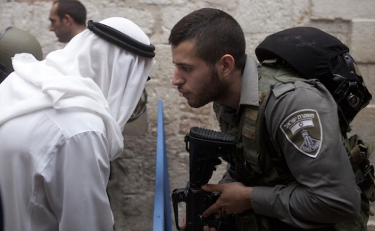 An Israeli border policeman speaking to a Palestinian man near the scene of a stabbing attack in Jerusalem’s Old City on Oct. 7