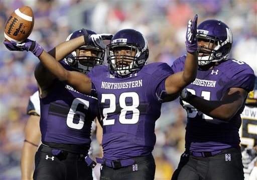 Northwestern running back Justin Jackson, center celebrates with wide receiver Tony Jones, left and wide receiver Tom Fuessel after scoring a touchdown during the second half of an NCAA college football game against California in Evanston