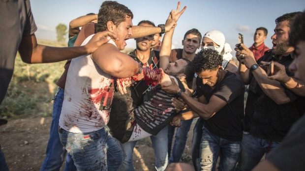 Palestinians carry a wounded man during demonstrations on the Israeli border in eastern Gaza City