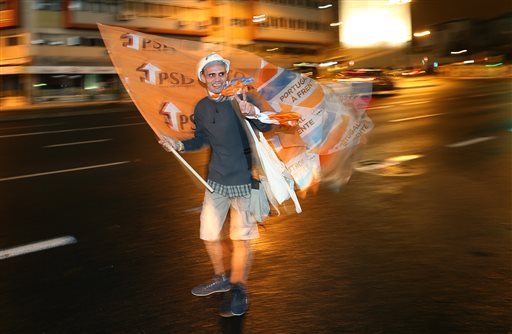 A center-right ruling coalition supporter celebrates on a street after the party won Portugal's general elections Sunday Oct. 4 2015 in Lisbon. The center-right coalition government earned another four-year term Sunday winning a general election