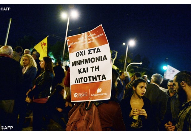 Protesters hold a sign reading 'No to bailout no to austerity&#39 in front of the Greek parliament in Athens- AFP