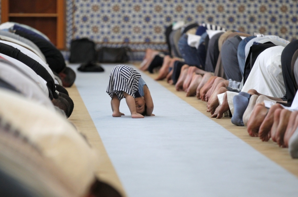 REUTERS  Vincent KesslerA child tries to emulate members of a Muslim community as they attend midday prayers at the Grand Mosque of Paris on Thursday