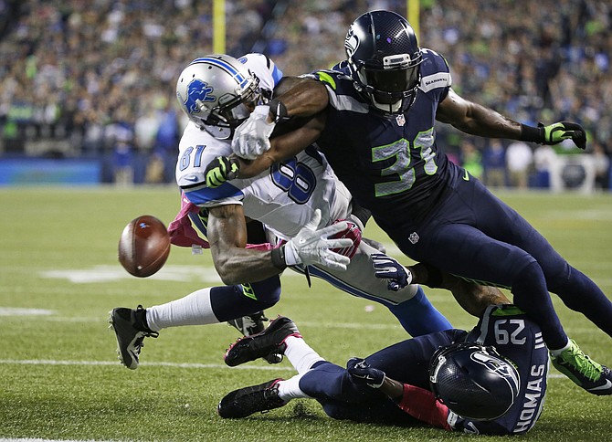 Detroit Lions wide receiver Calvin Johnson has the ball knocked loose by Seattle Seahawks strong safety Kam Chancellor late in the fourth quarter Monday in Seattle. The fumble went out of bounds in the end zone and was ruled a touchback. The Sea