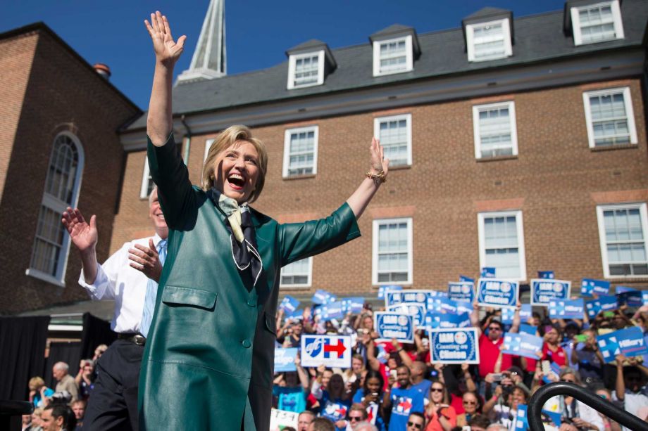 Democratic presidential candidate former Secretary of State Hillary Rodham Clinton accompanied by Virginia Gov. Terry McAuliffe smiles and waves as she arrive for a campaign rally Friday Oct. 23 2015 in Alexandria Va