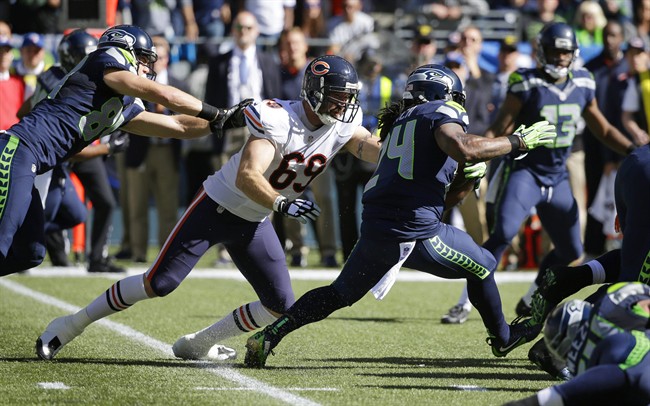 Seattle Seahawks running back Marshawn Lynch runs the ball as Chicago Bears outside linebacker Jared Allen reaches for a tackle attempt while being blocked by Seahawks tight end Cooper Helfet left in the first half of an NFL football game Su