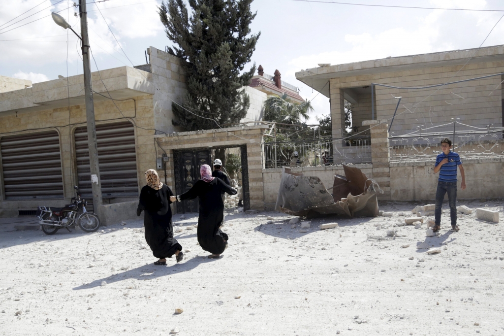 Women run at a site hit by what activists said were airstrikes carried out by the Russian air force in Kafranbel near Idlib Syria yesterday. – Reuters pic