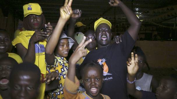 Supporters of Guinea president Alpha Conde gather in a street to celebrate his election victory