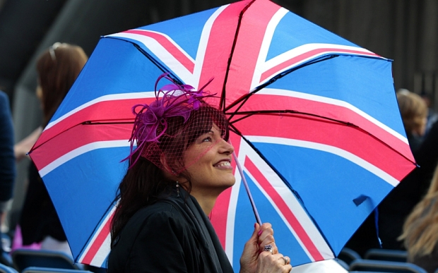 A royal fan sits with an Union flag umbrella during a special breakfast at St Andrews university in St Andrews