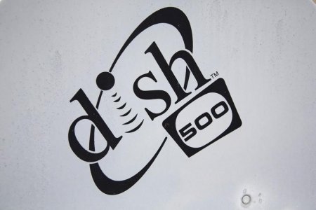 A Dish Network logo is seen on a satellite dish on a Brooklyn apartment building roof in New York