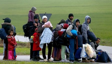 Migrants rest after crossing the Austrian German border in Wegscheid near Passau Germany