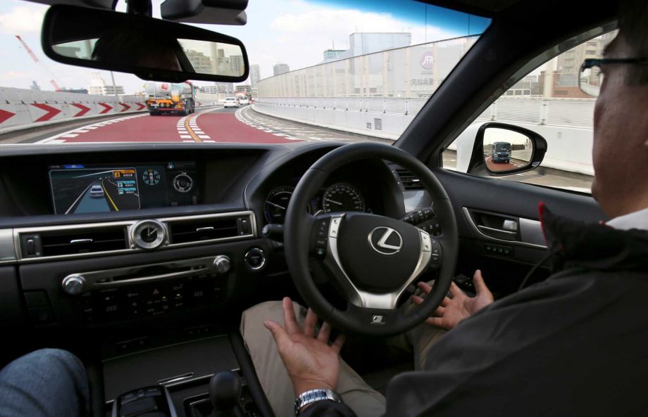 A Toyota employee takes a Lexus GS automated-driving test vehicle for a spin on Tuesday in Tokyo