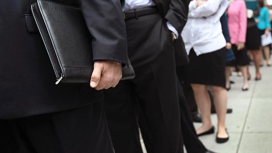 People stand in line to enter a job fair in New York