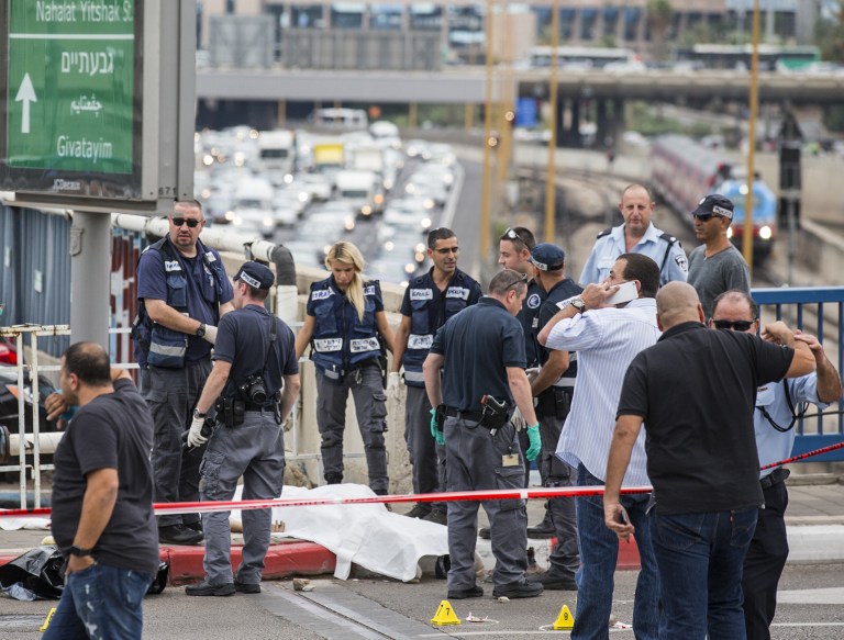 Israeli security forces inspect the body of a Palestinian man who was shot dead after carrying out a stabbing attack on an Israeli soldier and four passers-by in the coastal city of Tel Aviv