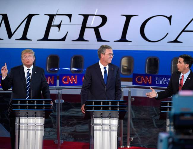 Then-Republican presidential candidate Wisconsin Gov. Scott Walker right speaks as Donald Trump left reacts and former Florida Gov. Jeb Bush listens during the CNN Republican presidential debate on Sept. 16 2015 in Simi Valley Calif