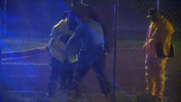 Investigators work through rain and strong winds after a gunman shot an off-duty New Orleans police officer Sunday night