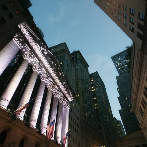 American flags fly in front of the New York Stock Exchange in New York. Global shares rose Thursday Oct. 15 2015 after weak economic figures in the U.S. reinforced expectations the Federal Reserve will