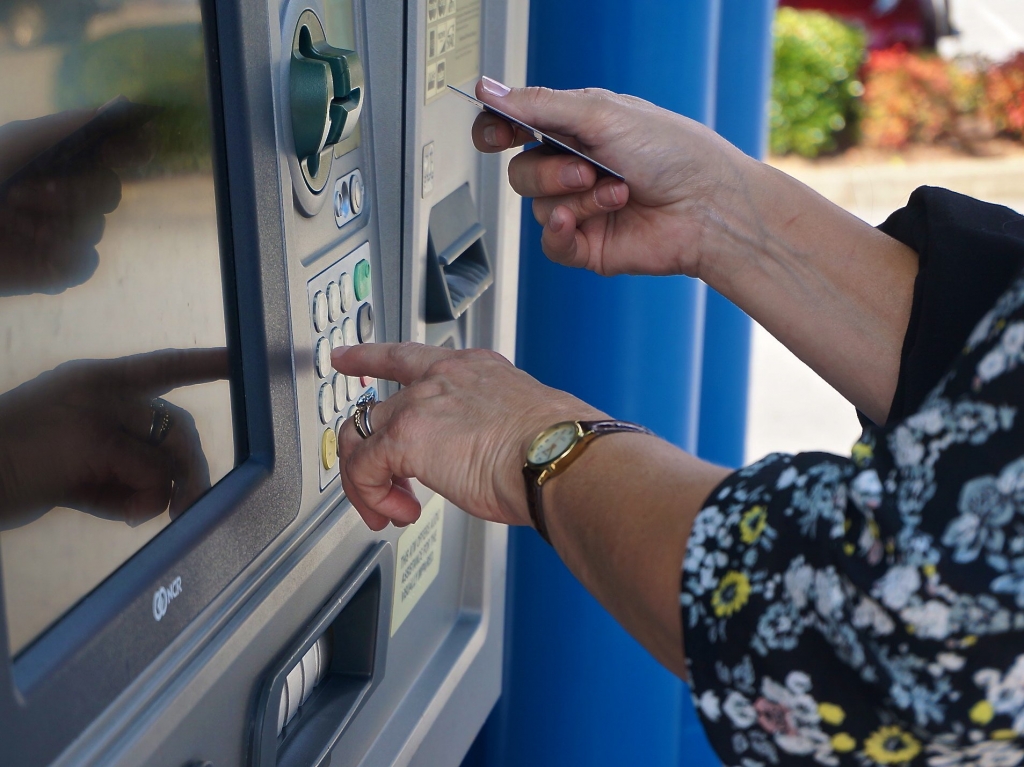 A woman withdraws cash from a Chase drive-up Automated Teller Machine or ATM