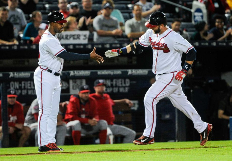 Atlanta Braves A.J. Pierzynski rounds their base to congratulations by coach Bo Porter left during a home run against the Washington Nationals in the seventh inning of a baseball game Tuesday Sept. 29 2015 in Atlanta