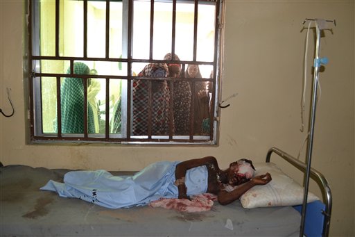 Women look through a window to see a victim of Thursday's suicide bomb explosion at a hospital in Maiduguri Nigeria Friday Oct. 16 2015. Four women suicide bombers blew themselves up early Friday when challenged by soldiers as they tried to enter