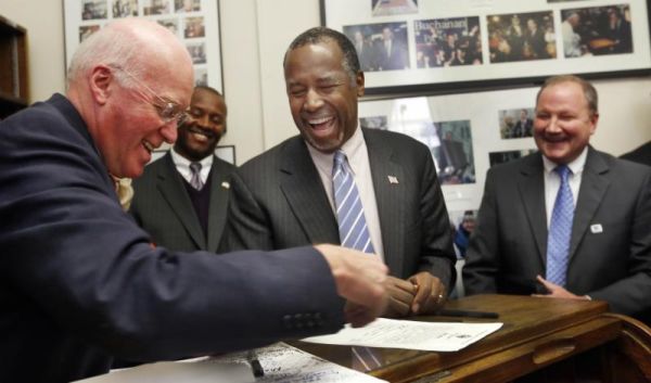 Republican presidential candidate Dr Ben Carson center laughs