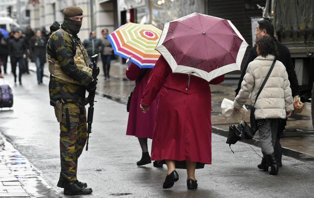 A soldier patrols outside a Brussels shopping center Saturday after the government put the city on its highest terror alert. All metro train stations in the city are now closed