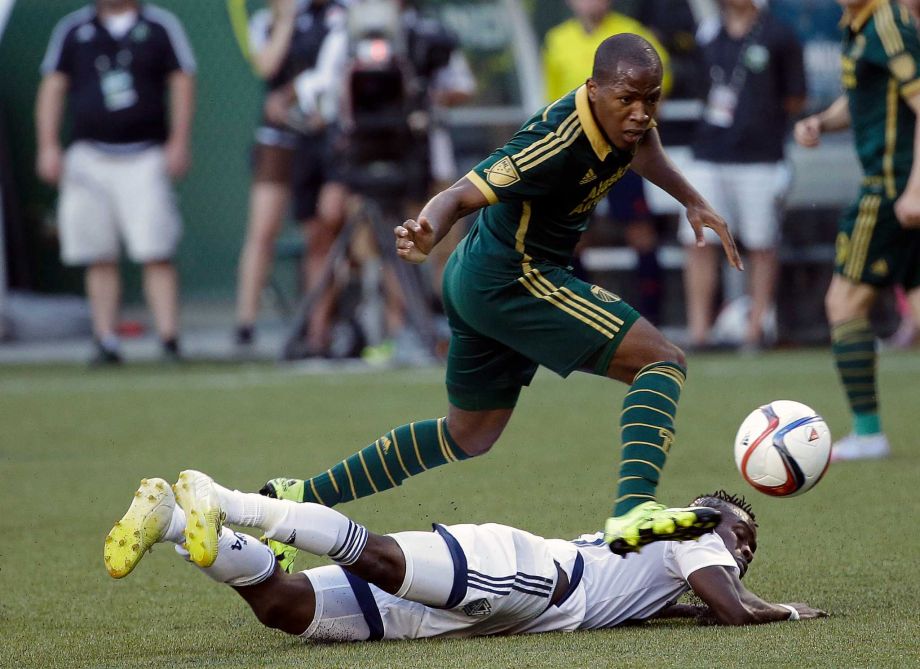 Portland Timbers forward Darlington Nagbe top leaps over Vancouver Whitecaps midfielder Gershon Koffie as he chases the ball during the first half of an MLS soccer game in Portland Ore. Portland Timbers midfiel