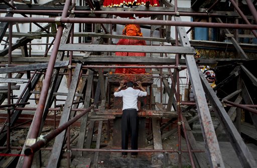 Nepalese man offers prayers at a temple damaged in the April 25 earthquake at the Basantapur Durbar square in Kathmandu Nepal. Aid groups are warning of a crisis unfolding in Nepal as winter approaches especially for the