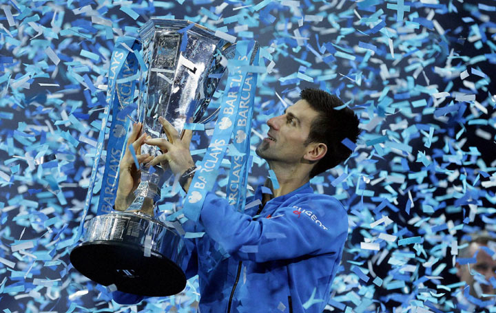 Novak Djokovic of Serbia holds aloft the winners trophy after he defeated Roger Federer of Switzerland in the season-ending ATP World Tour Finals in London