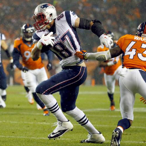 Patriots tight end Rob Gronkowski breaks free from Denver Broncos strong safety T.J. Ward for a touchdown during the first half of an NFL football game Sunday Nov. 29 2015 in Denver