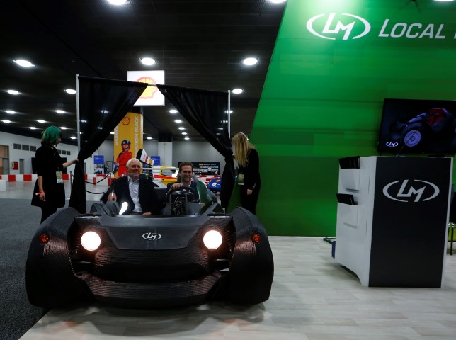 CEO and founder of Local Motors John B. Rogers and Milt Peterson of Peterson Companies showcase the world's first 3-D printed car the Strati during the first press preview day of the North American International Auto Show