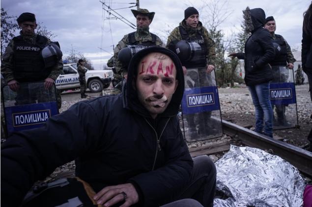 Bandages cover an Iranian migrant's lips that were sewn shut on Monday during a hunger strike at the Greek Macedonian border on Thursday