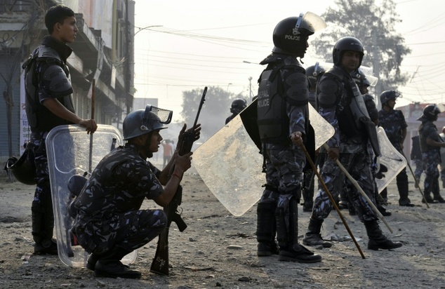 Nepalese riot police watch protesters near the Nepal India border some 90 km south of Kathmandu