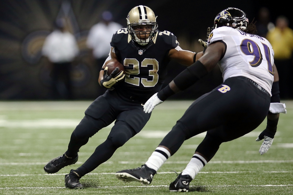 NEW ORLEANS LA- NOVEMBER 24 Pierre Thomas #23 of the New Orleans Saints is pursued by Courtney Upshaw #91 of the Baltimore Ravens during the third quarter of a game at Mercedes Benz Superdome