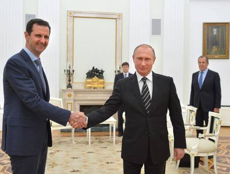 Russian President Vladimir Putin shakes hands with Syrian President Bashar al Assad during a meeting at the Kremlin