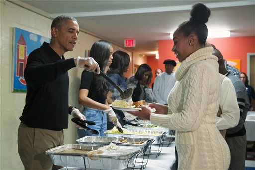 President Barack Obama from left Malia Obama and first lady Michelle Obama serve Thanksgiving dinner during'Feast with Friends at Friendship Place homeless center on Wednesday Nov. 25 2015 in Washington. Friendship Place works with homeless and