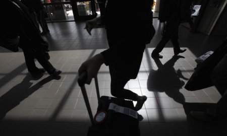 Passengers cast shadows as they walk along a terminal at Los Angeles International Airport in Los Angeles California